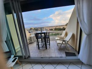 a balcony with chairs and a table with a view at naturiste in Cap d'Agde