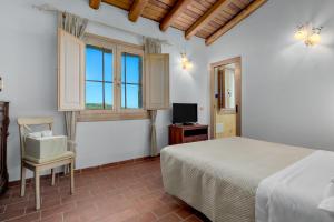 una camera con letto, TV e finestre di Casa Mare e Monti a Cannigione