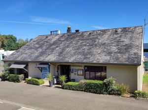 a house with a shingled roof on a street at Kyriad Tarbes Odos in Odos