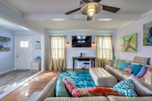 Una sala de estar con un sofá y un ventilador de techo. en Three Oars Beach Bungalow, en Daytona Beach