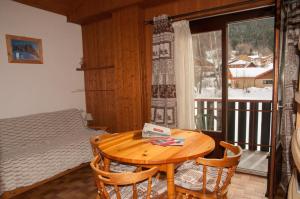 a room with a table and a bed and a window at 2 pièces Les Iris 20 Station Thollon les Mémises in Thollon