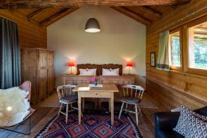 a room with a table and chairs and a bedroom at Berghütte Blockhaus in Redagno