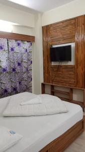 a bedroom with a bed and a window with a tv at Hotel The Grand Sandy in Cox's Bazar