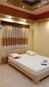 ein Schlafzimmer mit einem großen weißen Bett mit einem Vorhang in der Unterkunft Hotel The Grand Sandy in Cox's Bazar