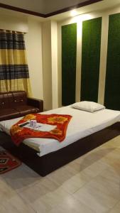 sypialnia z łóżkiem i krzesłem w pokoju w obiekcie Hotel The Grand Sandy w mieście Koks Badźar