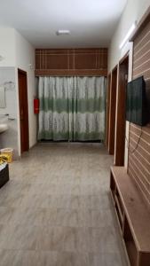 une pièce vide avec un rideau et une télévision dans l'établissement Hotel The Grand Sandy, à Cox's Bazar