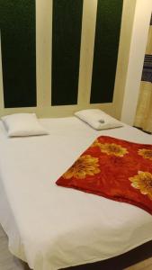 a white bed with a red pillow on it at Hotel The Grand Sandy in Cox's Bazar