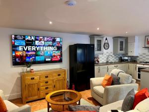 a living room with a large tv on the wall at 7 - Central Studio - King Bed - Bike Facilities in Merthyr Tydfil
