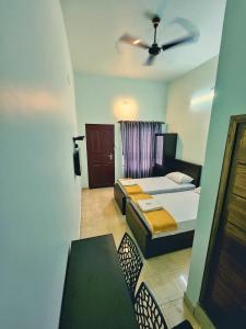 1 Schlafzimmer mit 2 Betten und einem Deckenventilator in der Unterkunft Apsara Residency in Perintalmanna