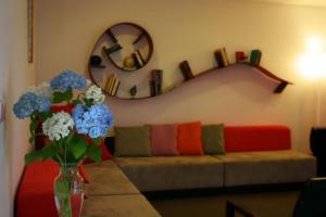 a living room with a couch and a vase of flowers at Casas do Soito in Seia
