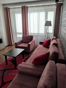a living room with a couch and a table at Apartament Red in Olsztyn