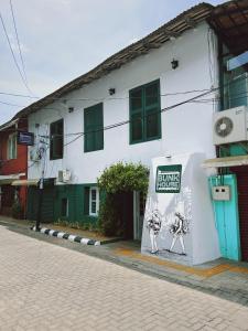 a white building with a sign on the side of it at Bunk house Fort Kochi in Cochin