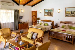 a bedroom with two beds and a living room at Villa Caballero in Au Cap