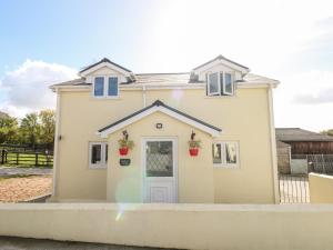 une maison individuelle avec une porte en face dans l'établissement Saddlers Cottage, Berllandeg Farm, à Clynderwen