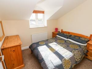 - une chambre avec un grand lit et une commode en bois dans l'établissement Saddlers Cottage, Berllandeg Farm, à Clynderwen