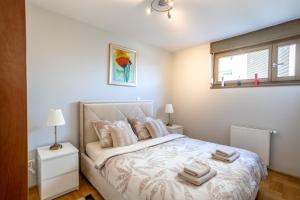 a bedroom with a white bed with a window at Luxurious apartment in the heart of Zagreb in Zagreb