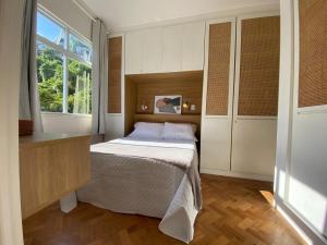 a small bedroom with a bed and a window at Elegância à Beira-Mar: Apto 1Qto c/ Smart TV in Rio de Janeiro