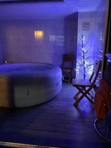 17 Cheerful 2 bed bungalow, hot tub/gym/pool table في برستاتين: غرفة بها حوض وشجرة عيد الميلاد
