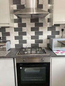 uma cozinha com um fogão e um micro-ondas em 17 Cheerful 2 bed bungalow, hot tub/gym/pool table em Prestatyn