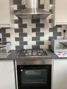 a kitchen with a stove and a microwave at 17 Cheerful 2 bed bungalow, hot tub/gym/pool table in Prestatyn