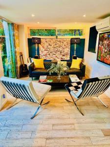 sala de estar con 2 sillas y sofá en Astoria Villa maison d hôtes Appartement vue mer avec piscine, en Cassis
