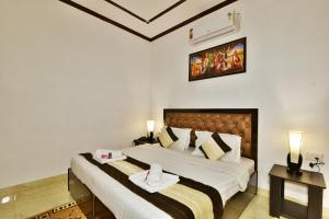 a bedroom with a large bed with two towels on it at Hotel Sai Sham in Amritsar