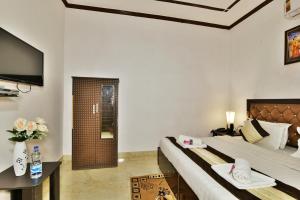 um quarto de hotel com uma cama e uma televisão de ecrã plano em Hotel Sai Sham em Amritsar