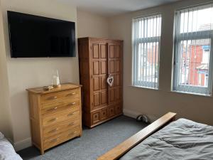 a bedroom with a dresser and a flat screen tv at Urban view in Doncaster