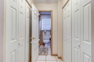 a bathroom with a toilet and a hallway with doors at Good Old Days Cottage King Bed Pet Friendly in Daytona Beach