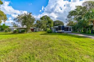 a yard with a house and a grass field at Good Old Days Cottage King Bed Pet Friendly in Daytona Beach