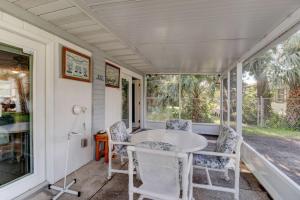 a porch with a white table and chairs at Good Old Days Cottage King Bed Pet Friendly in Daytona Beach