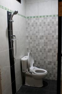 uma casa de banho com um WC e um chuveiro em Chillin Kuta Homestay em Kuta