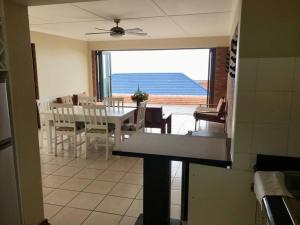 a dining room with a table and a view of the ocean at Bazley High Rocks Top Cottage in Bazley Beach