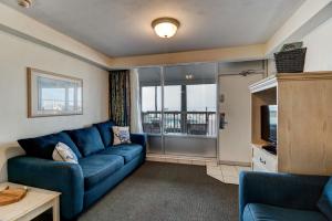 salon z niebieską kanapą i telewizorem w obiekcie Direct Oceanfront Condo with Kitchen w mieście Daytona Beach