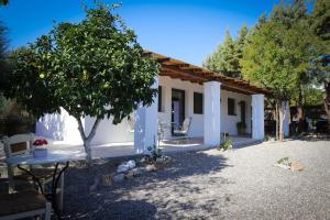 una pequeña casa blanca con un árbol delante en Lavender farm house, en Nafpaktos