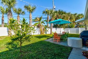 オーモンド・ビーチにあるTropical Retreatのパティオ(テーブル、青い傘付)