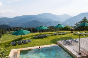 basen z leżakami, parasolami i górami w obiekcie Appartement im Grünweinhof w mieście Montagna