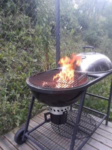 a bbq grill on a deck with fire at Apartamenti pie Lienes in Gardene