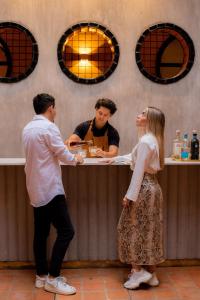 two men and a woman standing at a bar at Casa Hoyos - Hotel Boutique in San Miguel de Allende
