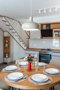 a dining room table with plates and wine glasses at Holiday house Mareta - outdoor swimming pool, 4 bedrooms, WIFI in Jadrija