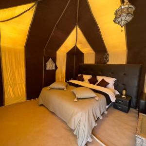 a bedroom with a large bed in a room at Fabulous Desert Camp in Merzouga