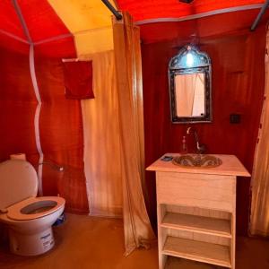 a bathroom with a toilet and a sink at Fabulous Desert Camp in Merzouga