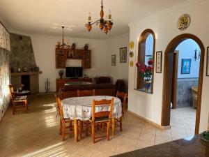 a dining room with a table and chairs and a living room at Casa Rural en Monda in Málaga