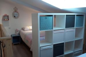ein Schlafzimmer mit einem Bett und einem weißen Bücherregal in der Unterkunft DUPLEX COSY Confort PISCINE in Caderousse