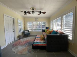 a living room with a couch and a ceiling fan at 3 Bed 2 Ba Wifi Kitchen Walk to Beach FirePit in Daytona Beach