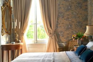 um quarto com uma cama e uma janela em Manoir de la Salle du Roc em Bourré
