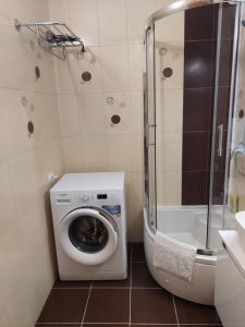 uma casa de banho com uma máquina de lavar roupa e um chuveiro em Sonata em Belgrado
