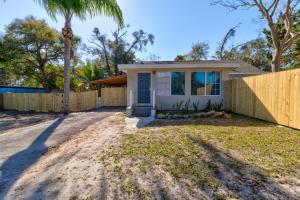 a house with a fence and a palm tree at The Gypsy Mermaid 3 Bed Ginormous Yard in Daytona Beach