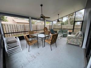 un porche cubierto con mesa y sillas en Relaxing 3 bed 2 bath Wifi by the Intercostal, en Daytona Beach