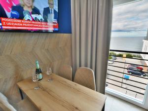 - une table à manger avec 2 verres à vin et une télévision dans l'établissement Comfortable apartment right by the sea, Ustronie Morskie, à Ustronie Morskie